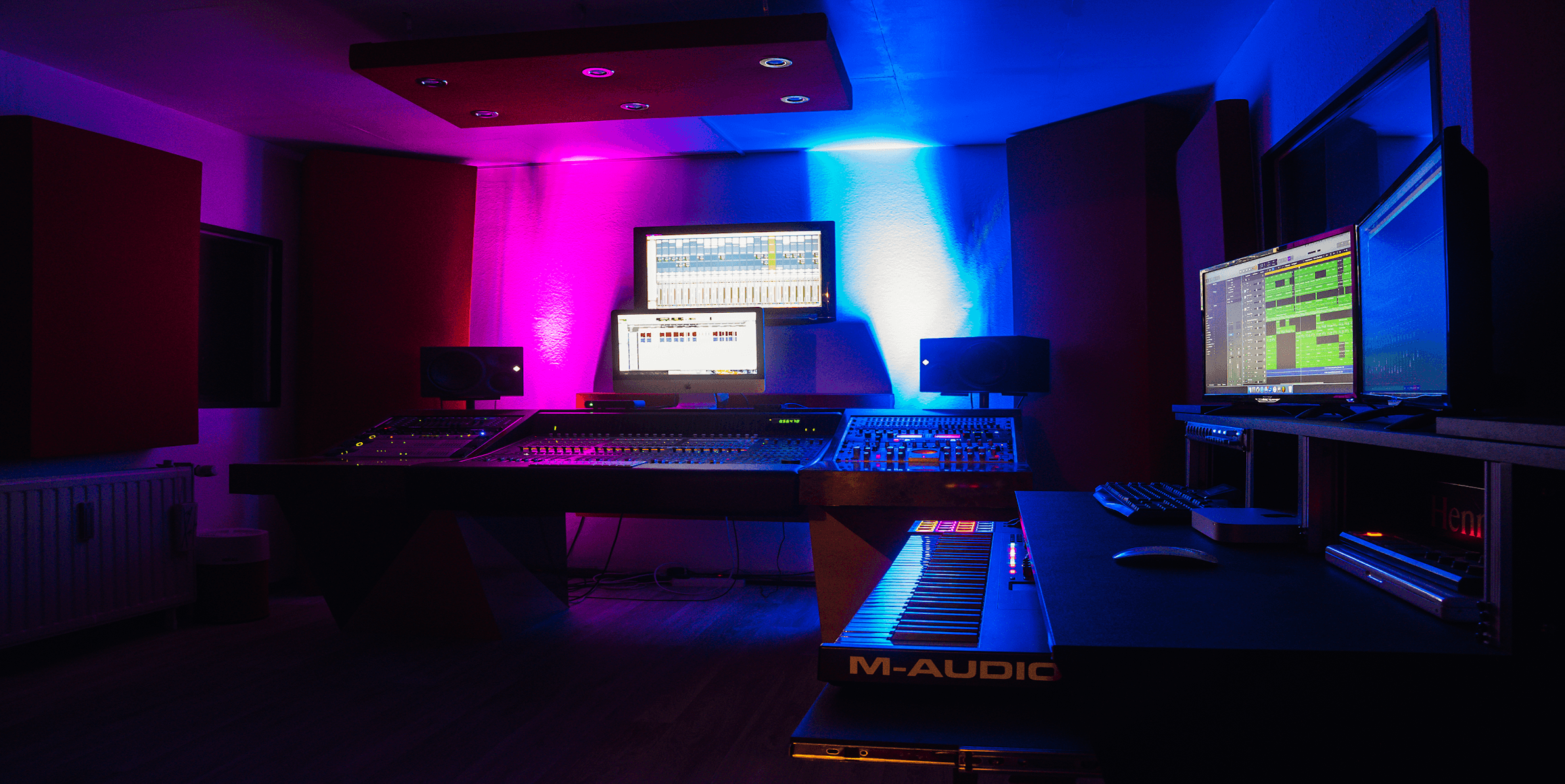Tonstudio Regieraum mit Mischpult, Lautsprecher, Monitore, Keyboard, offenen Projekten in der Audio Software sowie Breitbandabsorber an den Wänden und Deckensegel an der Decke.